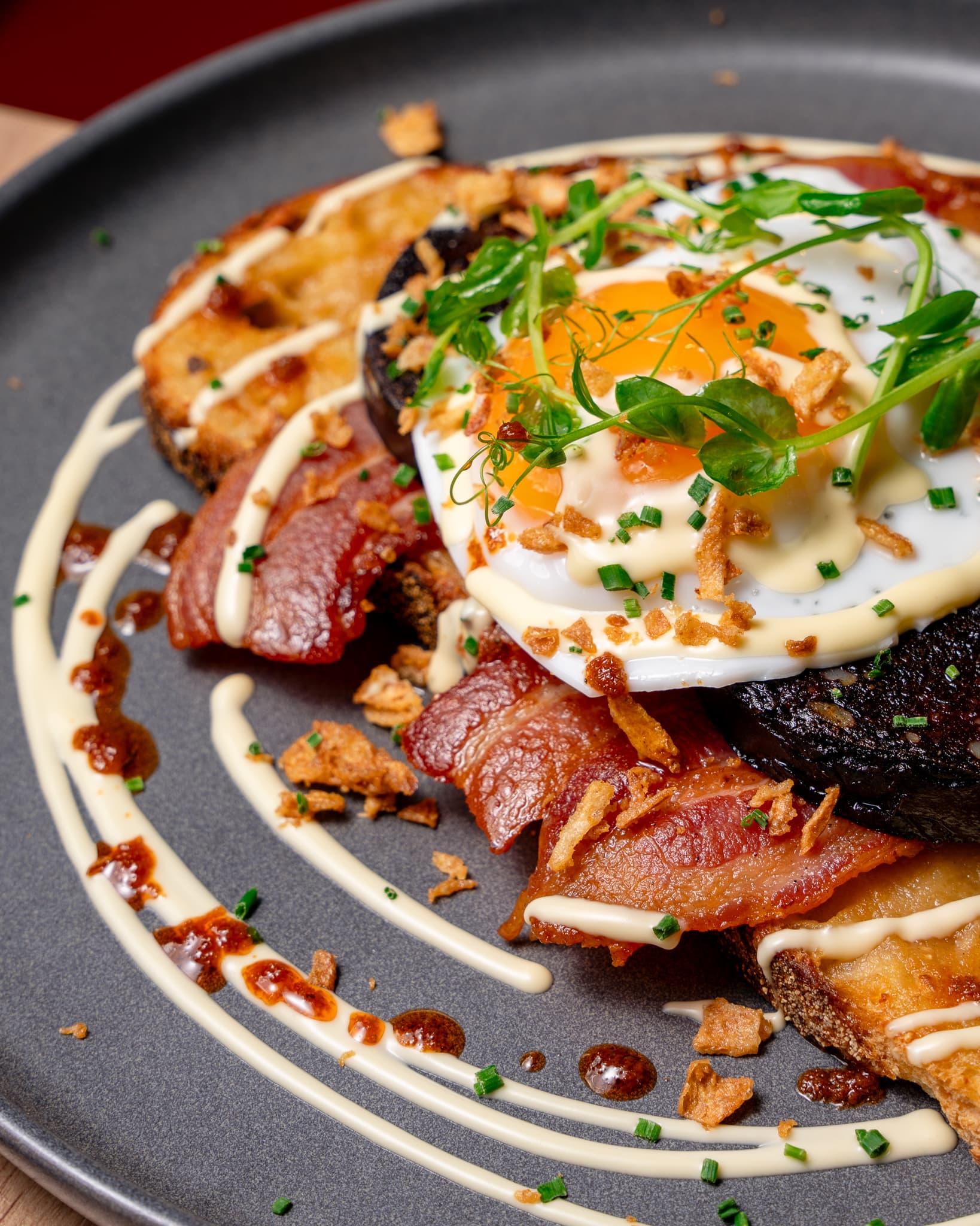 A breakfast plate with eggs, bacon and mushrooms