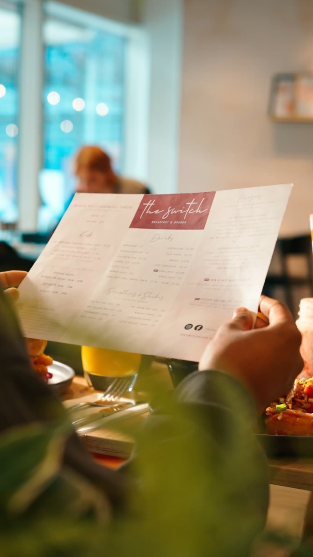 A guest holding The Switch Cafe menu